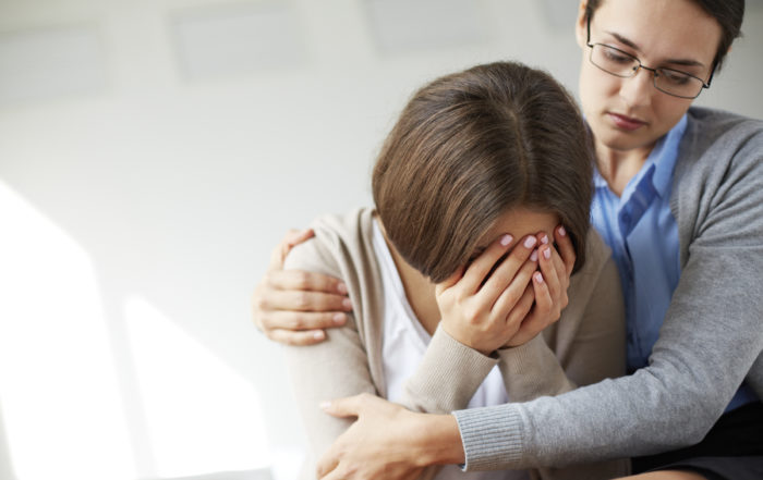 A social worker comforting a client dealing with mental health issues